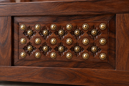 Close-up of walnut finish and brass detailing on Sheesham wood bed