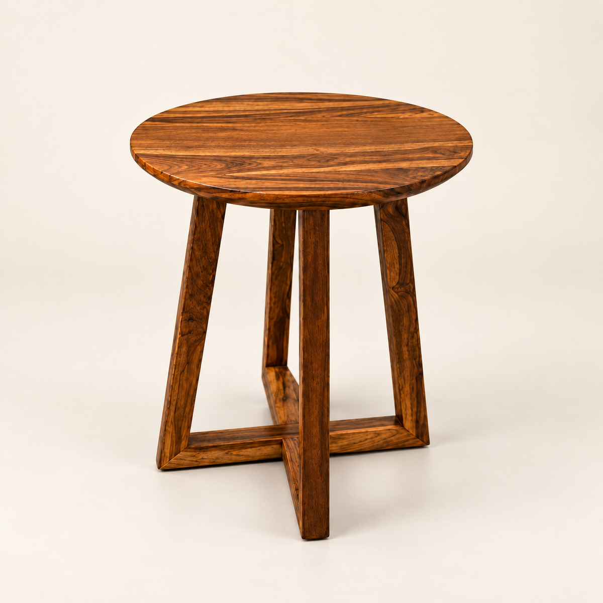 A round wooden side table with a rich dark brown grain pattern, featuring a thick circular top and four angled legs that intersect at the base, photographed on a clean off-white background.