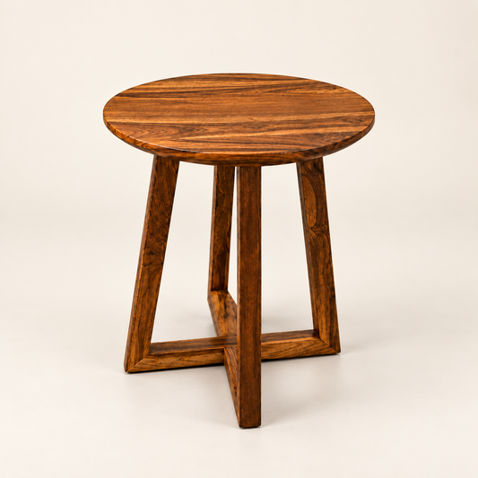 A round wooden side table with a rich dark brown grain pattern, featuring a thick circular top and four angled legs that intersect at the base, photographed on a clean off-white background.