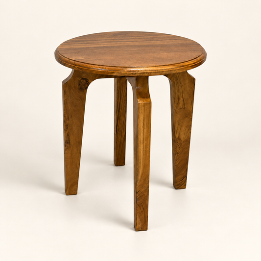 A round wooden side table with four legs, featuring a warm medium-brown finish and visible wood grain, photographed on a clean off-white background.
