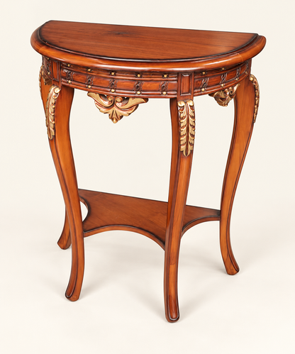 An ornate carved wooden console table with a warm brown finish, featuring decorative gold-toned accents and a lower shelf, photographed on a light cream background.