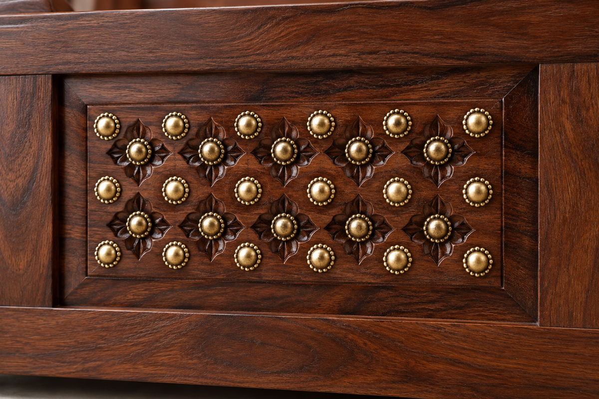 Close-up of walnut finish and brass detailing on Sheesham wood bed