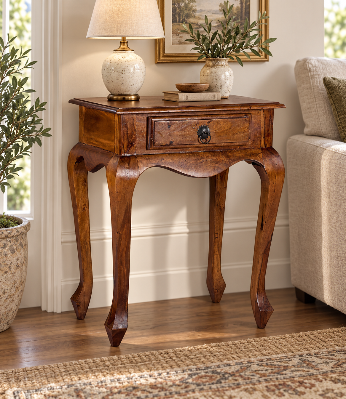 Wooden Side Table with Drawer and Curved Legs in teak wood, shown in a furnished room.